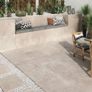 Patio con pavimento cerámico efecto piedra, banco integrado, losas sobre grava y mesa madera