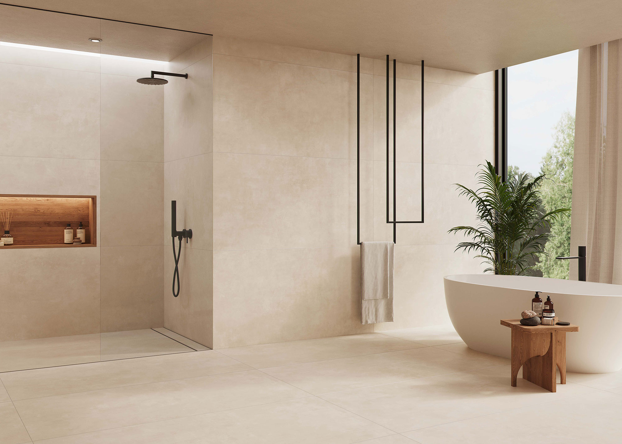 AMB-KTL_COLUMBIA-SAND_75x150-R_BAJA Exposición de baño con azulejos beige, ducha a la italiana negra, bañera exenta y planta