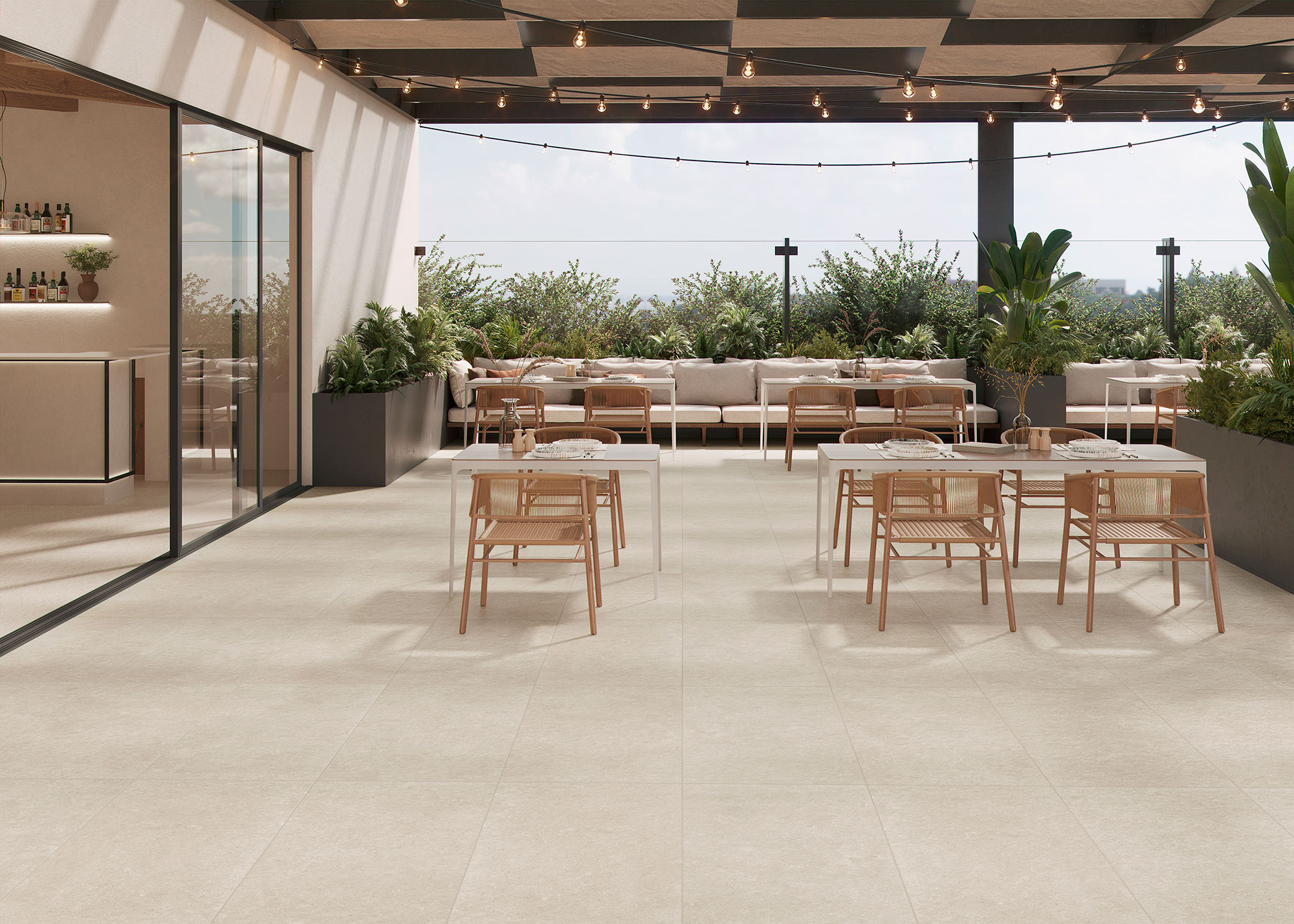 Terraza expositora con pavimento cerámico beige, mesas y sillas de madera y jardineras