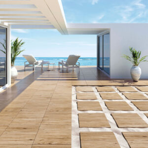Terraza con pavimento cerámico imitación madera, tumbonas y vista al mar