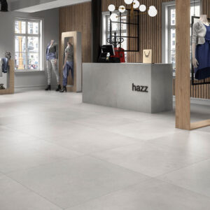 Tienda con pavimento cerámico gris claro, maniquíes y mostrador moderno