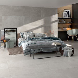Dormitorio moderno con azulejos cerámicos gris claro en suelo, pared y cama rayada