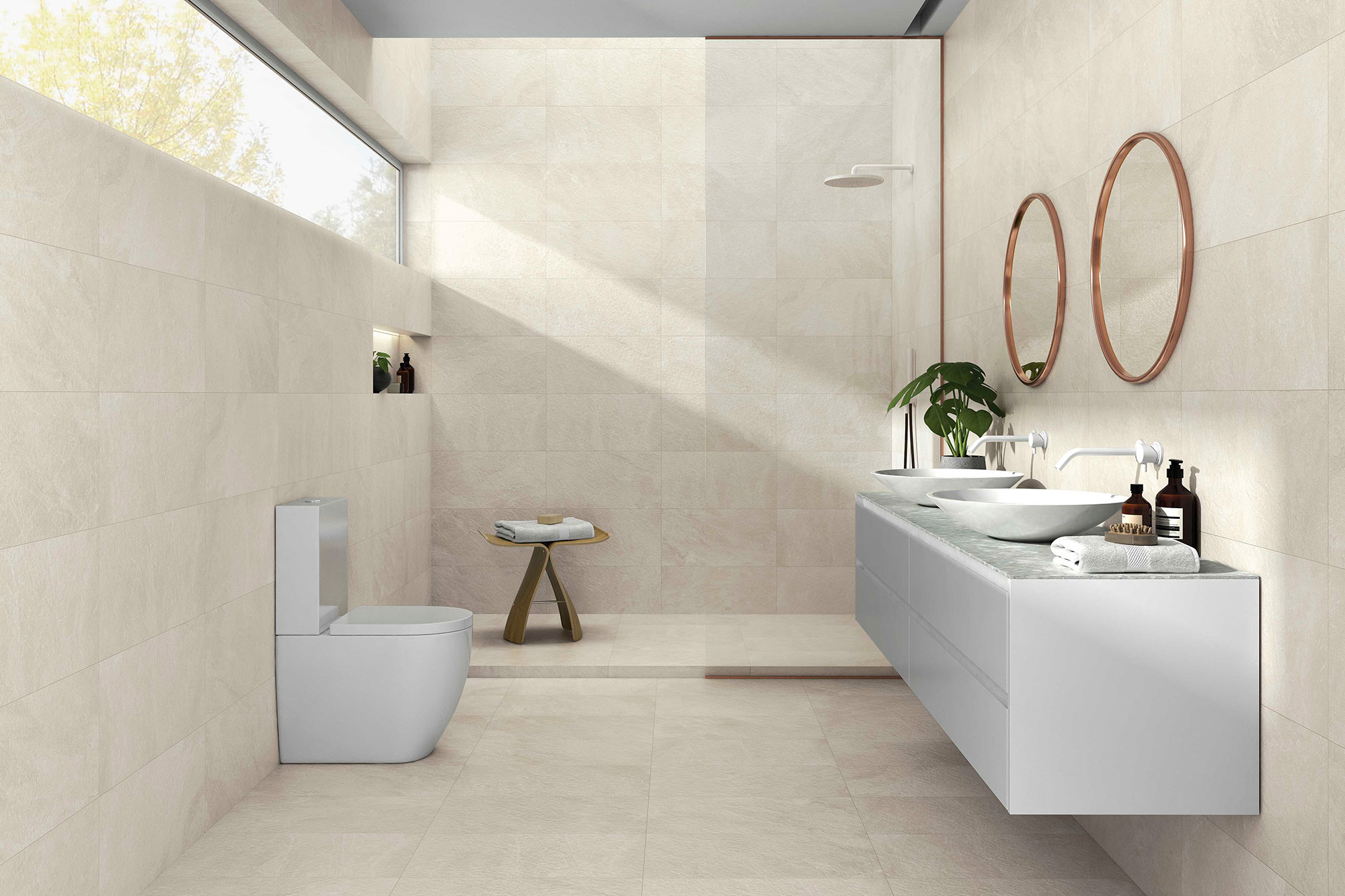 Baño minimalista con azulejos beige, lavabo doble, espejos redondos y ducha abierta