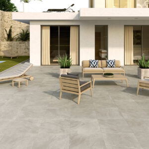 Terraza exterior con pavimento cerámico gris claro efecto piedra, mobiliario lounge y piscina