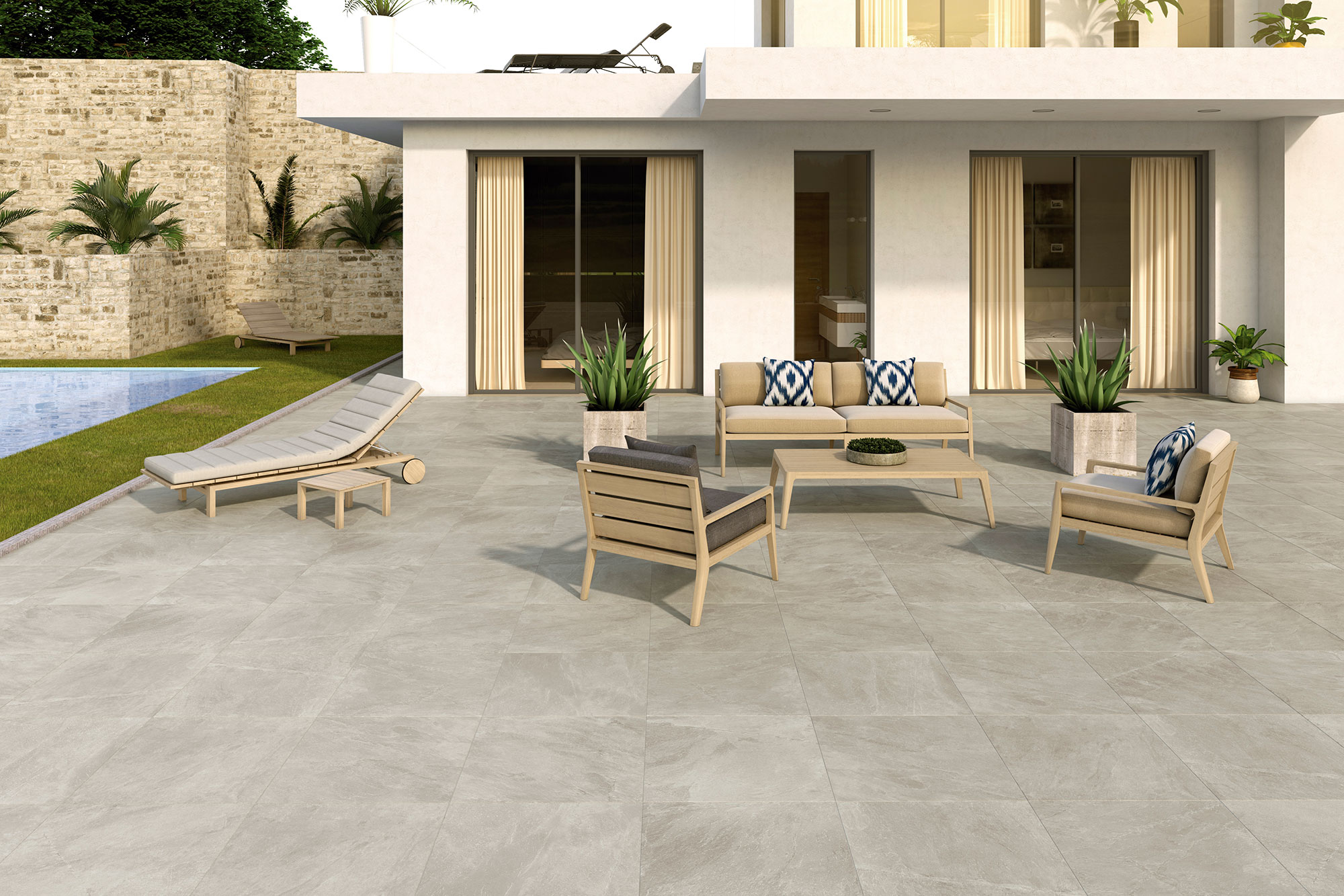 Terraza exterior con pavimento cerámico gris claro efecto piedra, mobiliario lounge y piscina