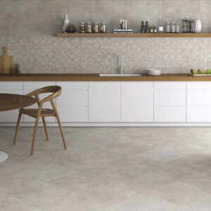 Ambiente de cocina con pavimento y revestimiento cerámico gris, encimera madera y muebles blancos