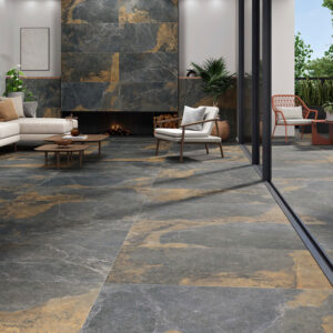 Salón y terraza unidos por grandes losas cerámicas efecto pizarra gris con vetas ocres
