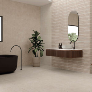 Baño exposición con azulejos crema, bañera negra, lavabo flotante, espejo oval y planta