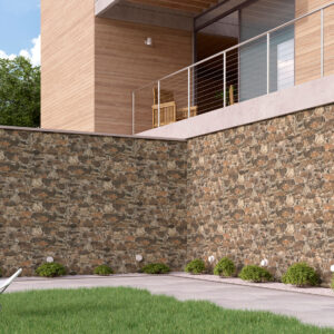 AMBIENTE-muralla-arena Fachada exterior con revestimiento cerámico efecto piedra, patio con césped y silla blanca
