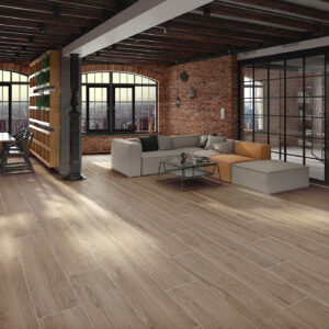 Loft showroom con suelo cerámico efecto madera, paredes de ladrillo y zona salón-comedor