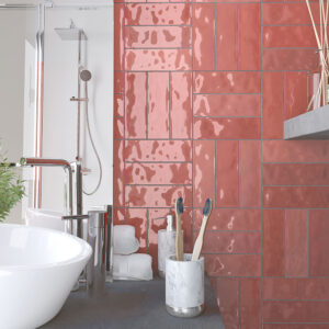 Lavabo y grifo cromado frente a azulejos cerámicos rosa brillante en patrón entrelazado