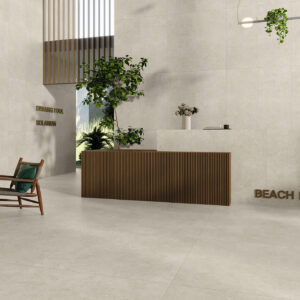 Recepción minimalista con grandes azulejos beige en suelo y paredes, mostrador madera y plantas