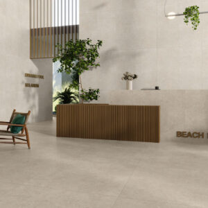 Recepción con suelos, paredes y mostrador en azulejos beige; sillón, plantas