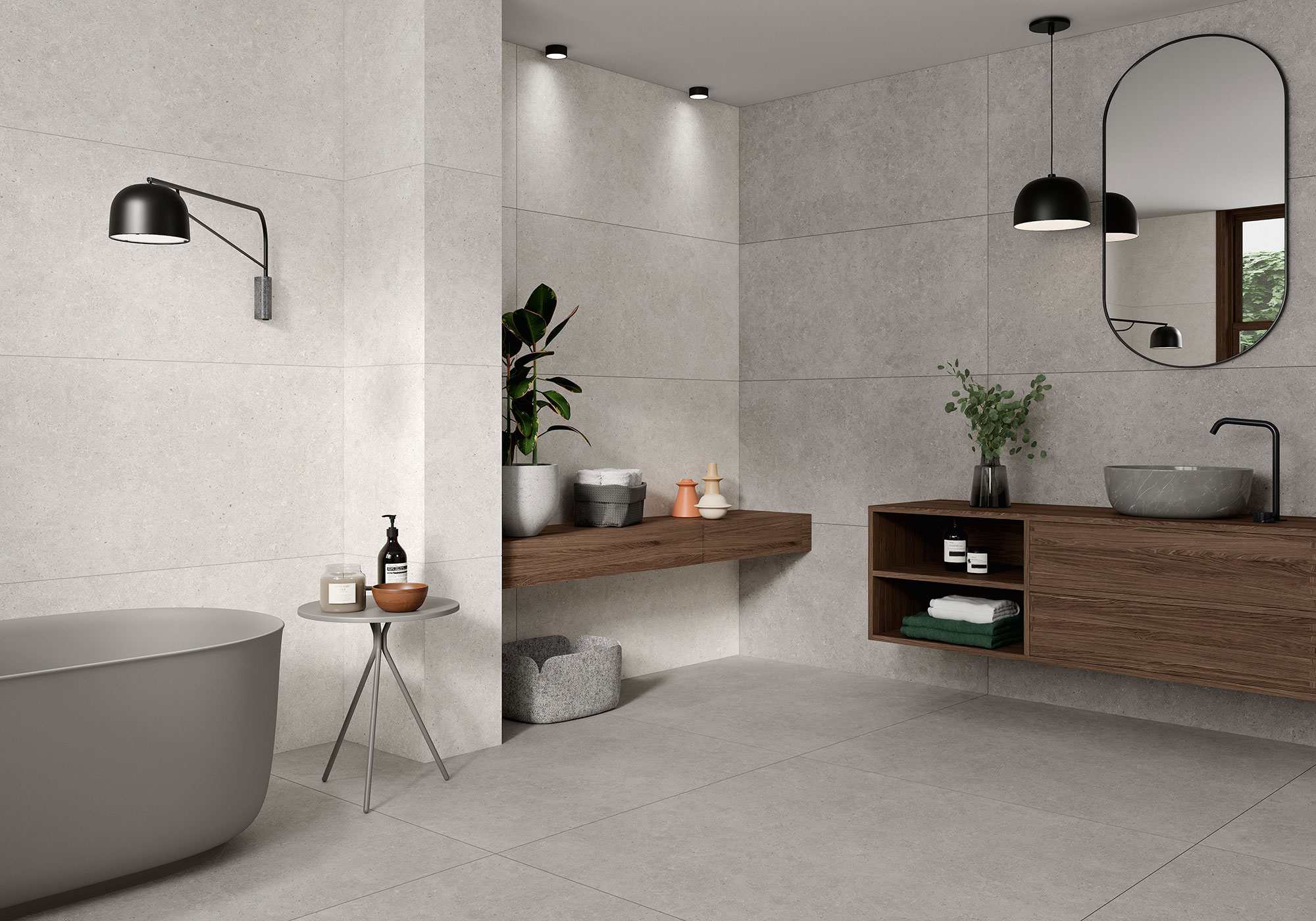 Baño minimalista con grandes azulejos grises, bañera exenta y mueble flotante de madera.