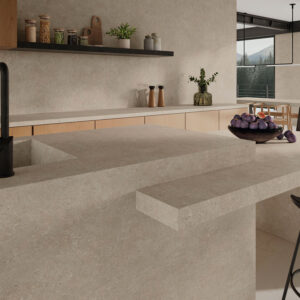 Cocina moderna con isla y revestimiento cerámico beige, grifo negro y cuenco de higos.