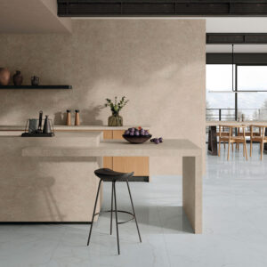 Cocina de exposición con revestimientos cerámicos beige en isla y suelos blancos veteados