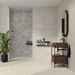 Expositor de baño con azulejos beige, panel decorativo, lavabo marrón, espejo ovalado y planta