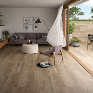 Salón con suelo y revestimiento cerámico efecto madera continuos hacia terraza exterior