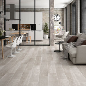 Sala y cocina abiertas en exposición con pavimento cerámico efecto madera claro.