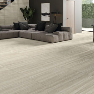 Salón con suelo cerámico beige efecto veta, sofá modular y comedor junto a ventana