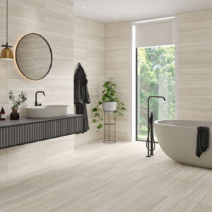 Baño moderno con pavimento y revestimiento cerámico beige, bañera exenta y lavabo flotante.