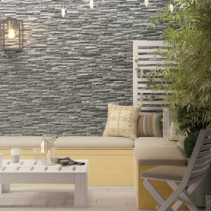 Rincón exterior con revestimiento cerámico efecto piedra, banco, cojines y plantas