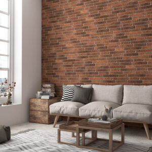 Salón con revestimiento cerámico tipo ladrillo, sofá gris y ventana panorámica