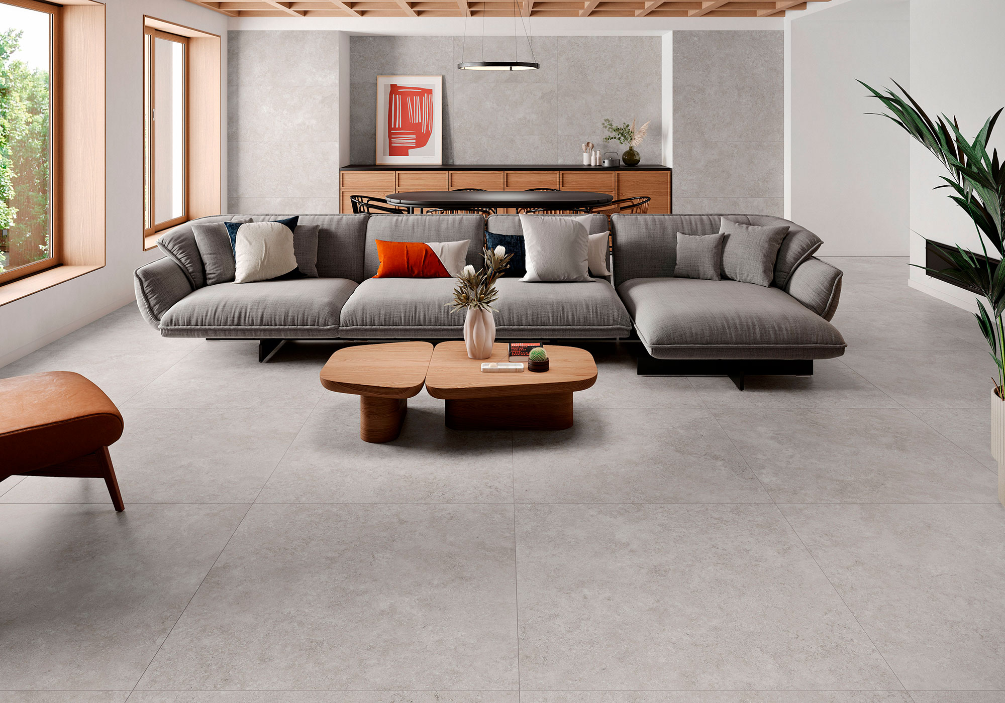 Salón de exposición con pavimento cerámico gris, sofá modular y mesa de madera