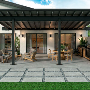 Patio con grandes losas cerámicas separadas por grava, pérgola y zona lounge y cocina