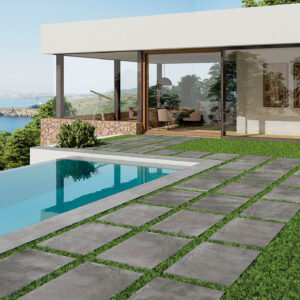 Exterior_Sonder_60x90_HD-ANTHRACITE Terraza con piscina y pavimento cerámico de losas grises sobre césped