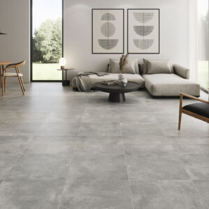Exposición de pavimento cerámico gris gran formato en sala moderna con mobiliario minimalista.