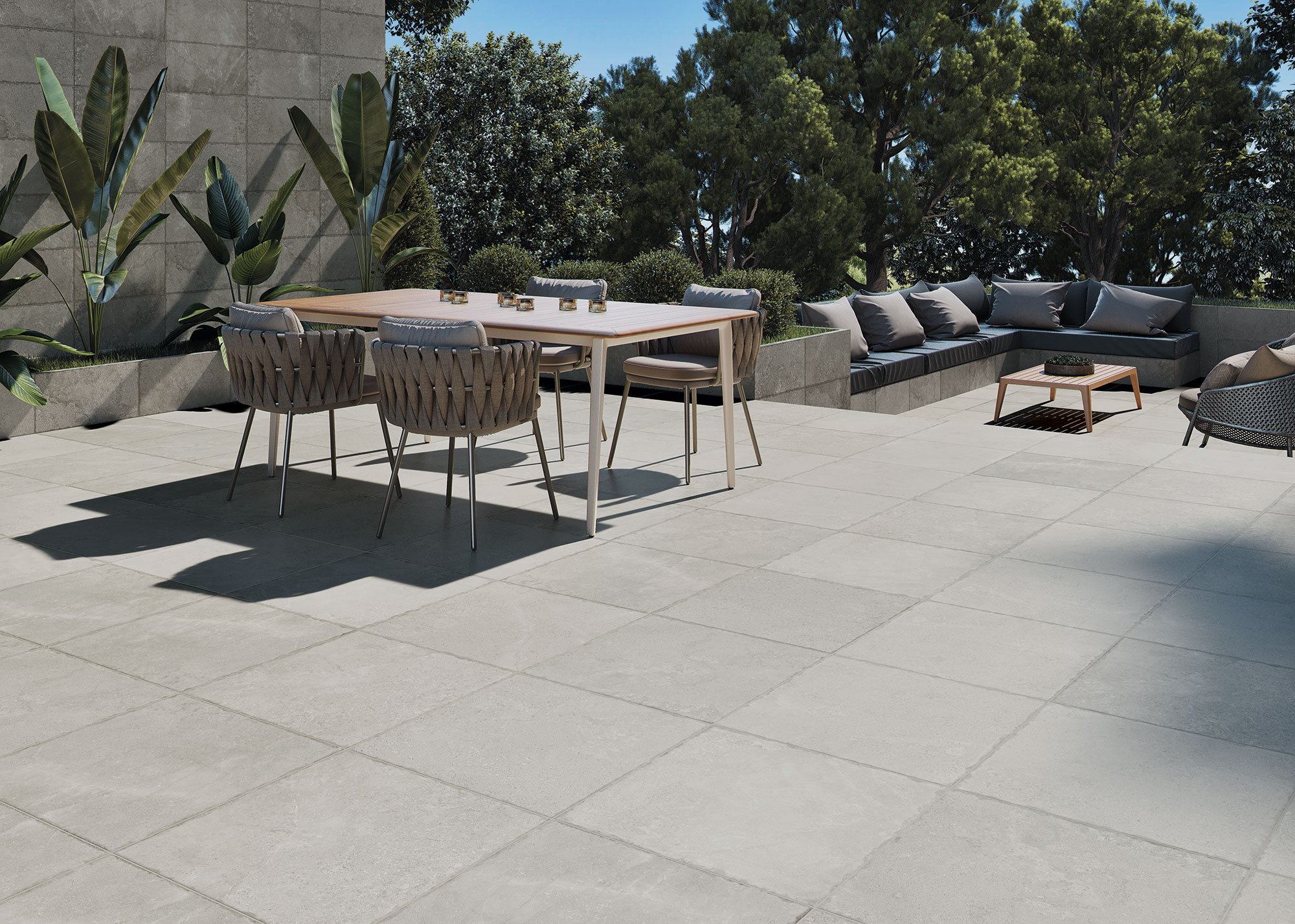 Terraza con pavimento cerámico gris, mesa de comedor y rincón de sofás