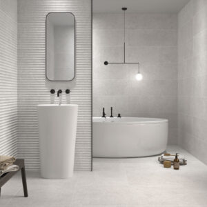 Baño minimalista con azulejos cerámicos claros, revestimiento texturizado, lavabo y bañera