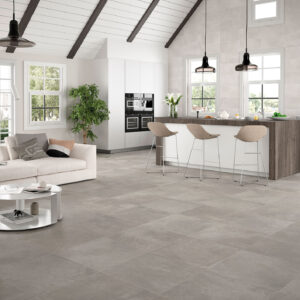 Salón-cocina abierto con grandes pavimentos cerámicos grises, isla y ventanales