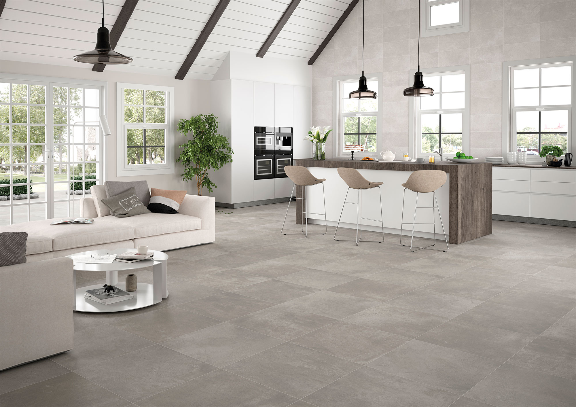 Salón-cocina abierto con grandes pavimentos cerámicos grises, isla y ventanales