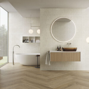 Showroom baño con revestimiento cerámico beige, suelo espiga efecto madera, bañera y mueble flotante