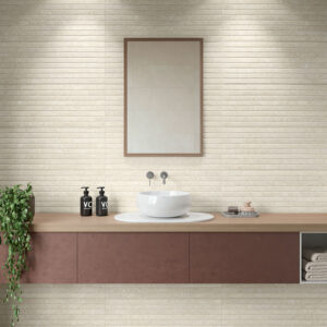 Lavabo sobre encimera de madera con revestimiento cerámico beige estriado, espejo y toallas.