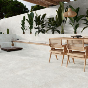 Terraza con pavimento cerámico claro, mobiliario en madera y pared ajardinada