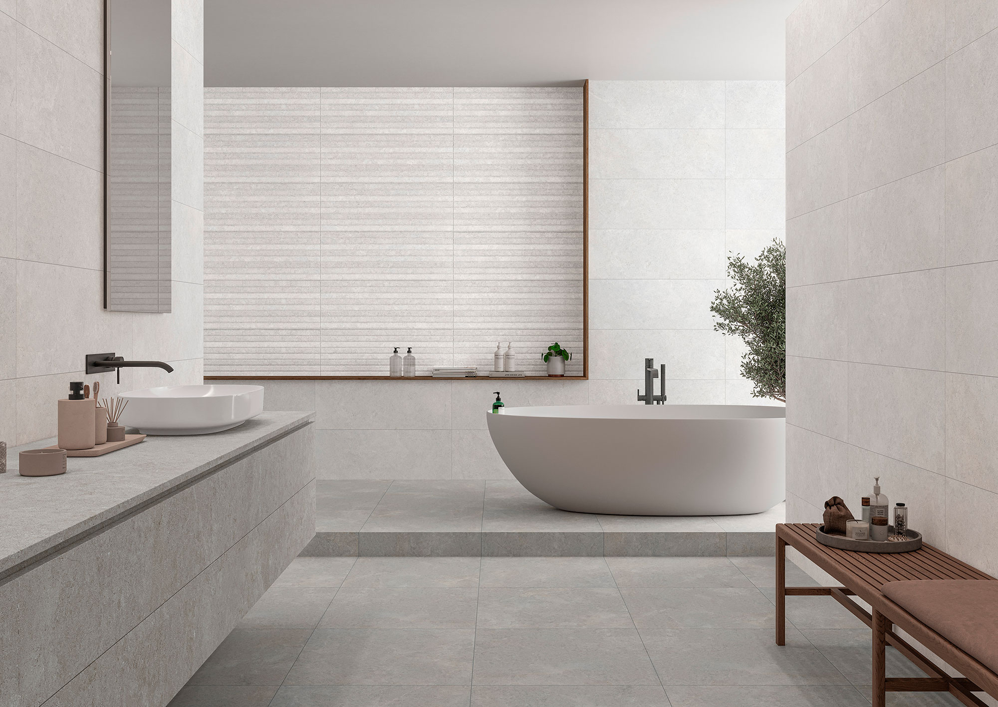 Baño expositivo con pavimento y revestimiento cerámico gris, bañera exenta y lavabo