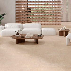 Tienda de azulejos con suelo beige, sofá blanco, mesas y separador de madera.