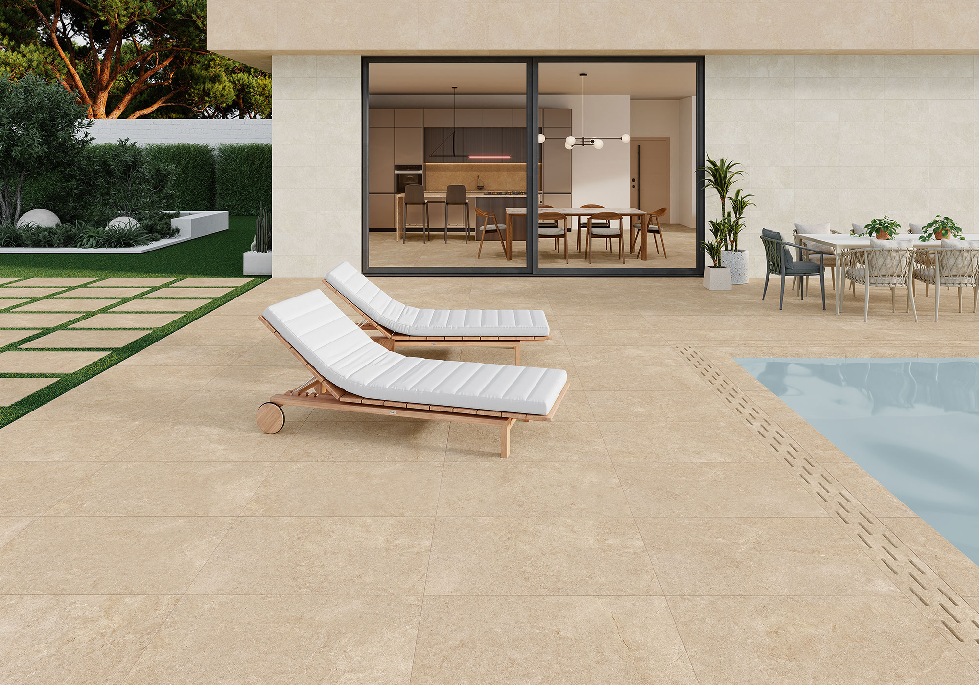 Terraza junto a piscina con gres beige efecto piedra, tumbonas blancas y comedor exterior