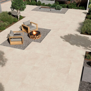 Patio con pavimento cerámico beige, dos sillones de madera y hoguera en área de grava