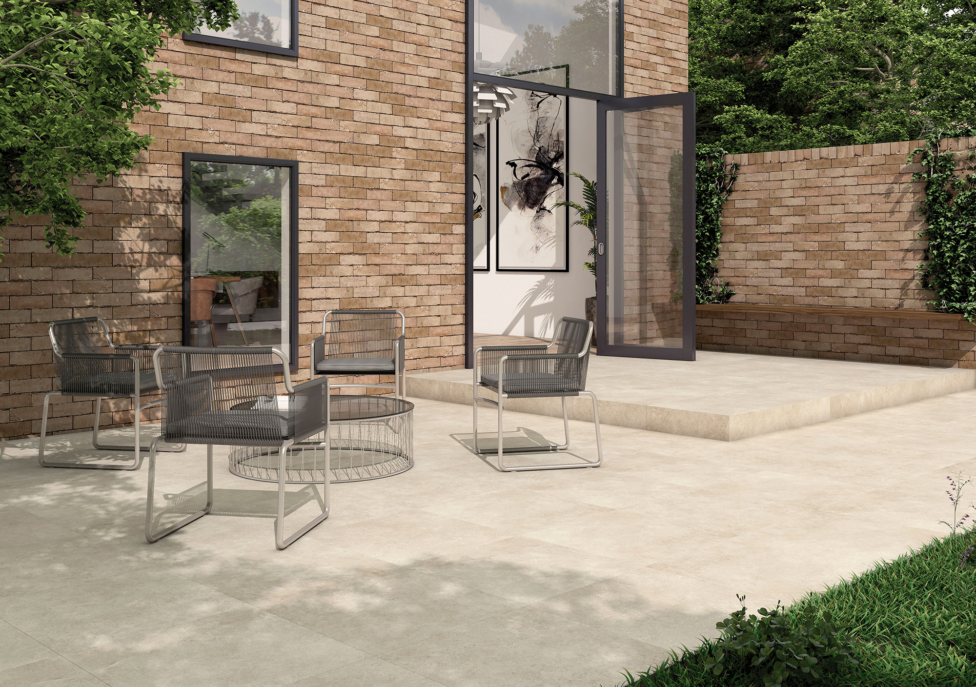 Terraza con azulejos cerámicos claros, pared de ladrillo y mobiliario exterior minimalista