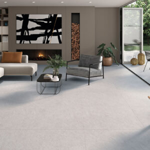 Salón moderno con grandes losas cerámicas claras que continúan hacia terraza ajardinada