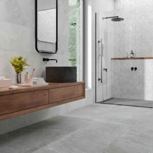 Baño moderno con pavimento y revestimiento cerámico gris, ducha de obra y mueble flotante