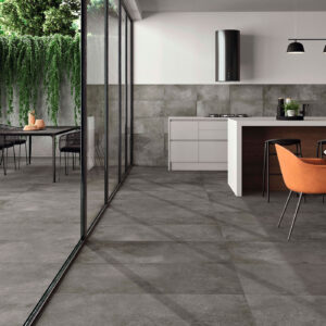 Cocina y terraza integradas con suelo y alzado de grandes losas cerámicas grisáceas