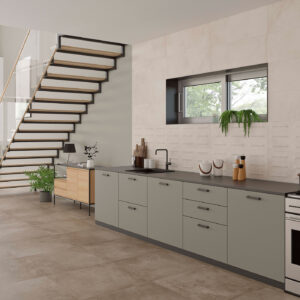 Cocina de exposición con pavimento y revestimiento cerámico beige, escalera flotante y encimera gris