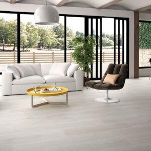 Salón moderno con pavimento cerámico efecto madera claro, sofá blanco y ventanales