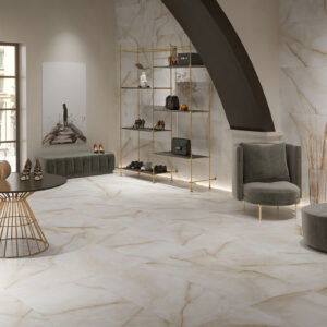 STN-AMB-BALTRA_IVORY_SAT Showroom de azulejos y pavimentos efecto mármol, con mobiliario y estanterías doradas