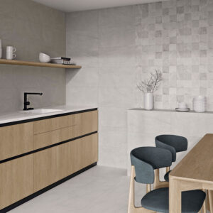 STN-AMB-BELLEVUE-GREY_WHITE-30x60 Cocina expositora con azulejos grises, panel mosaico, encimera blanca y muebles de madera.